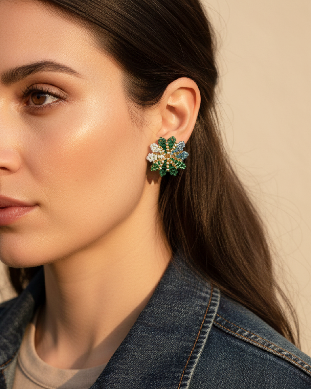 Green and aqua Miyuki flower stud with gold center on model’s ear.