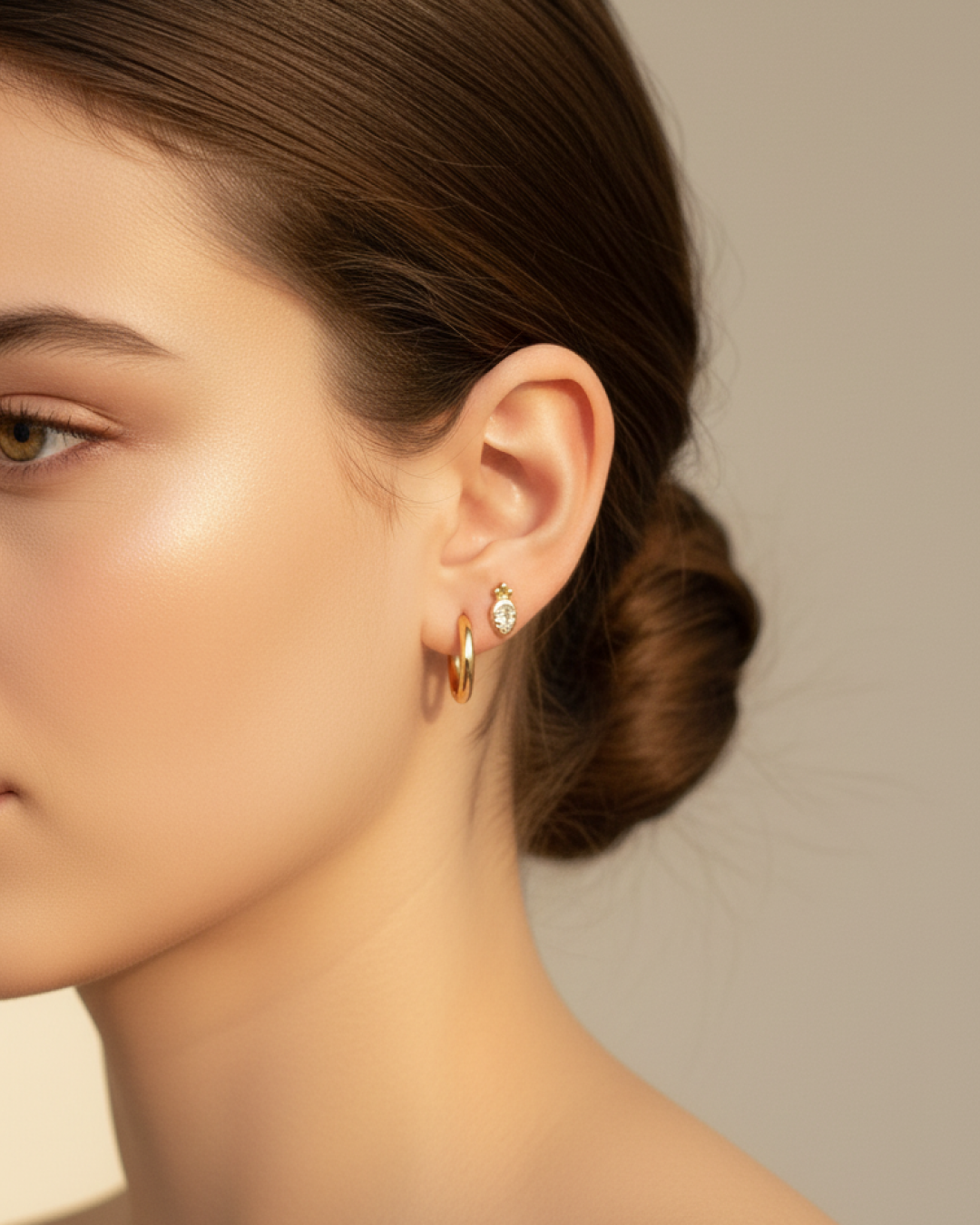 Tiny carrot CZ stud in second piercing above a gold hoop earring on model