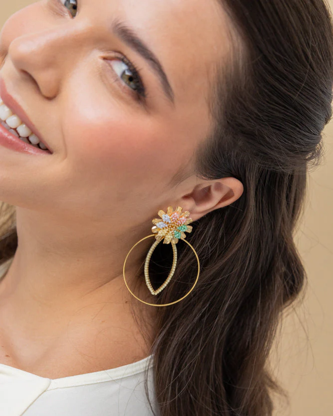 Model wearing pastel Miyuki flower dangle earrings with a large golden hoop, side profile.