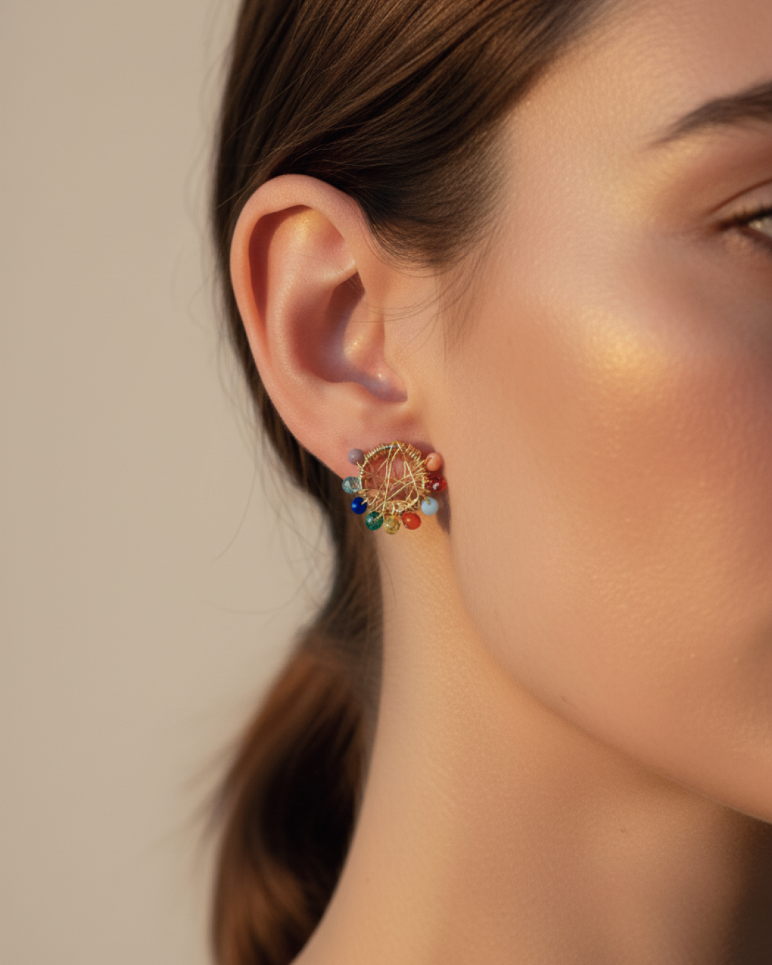 Gold circular stud with multicolor Murano beads on a woman’s ear under warm afternoon light.