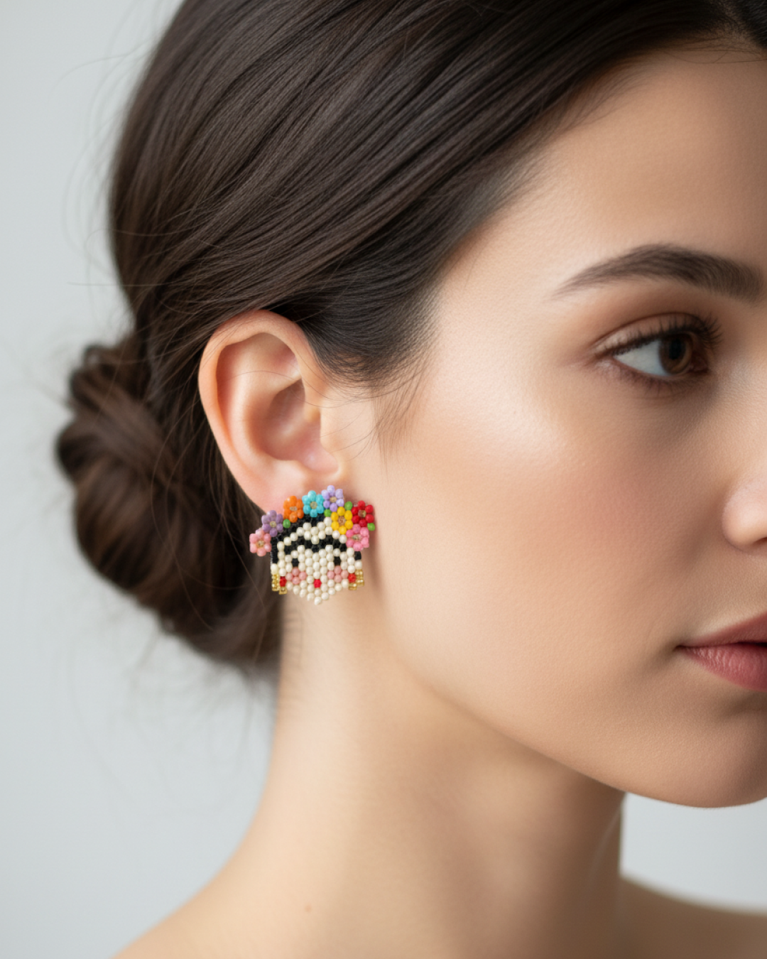 Multicolor Miyuki Frida stud earring on model’s earlobe against a light background.